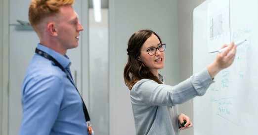 Two Co-Workers at a White Board